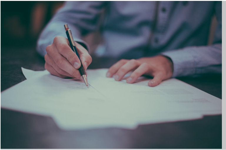 person writing on a document